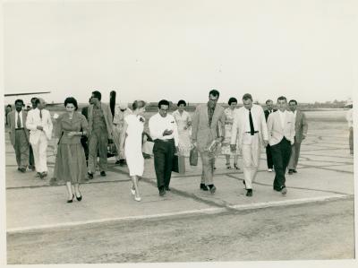 Dave Brubeck (with bouquet) amidst US Embassy officials, Joe Morello and Eugene Wright in background with Iraqi officials (Baghdad, Iraq)