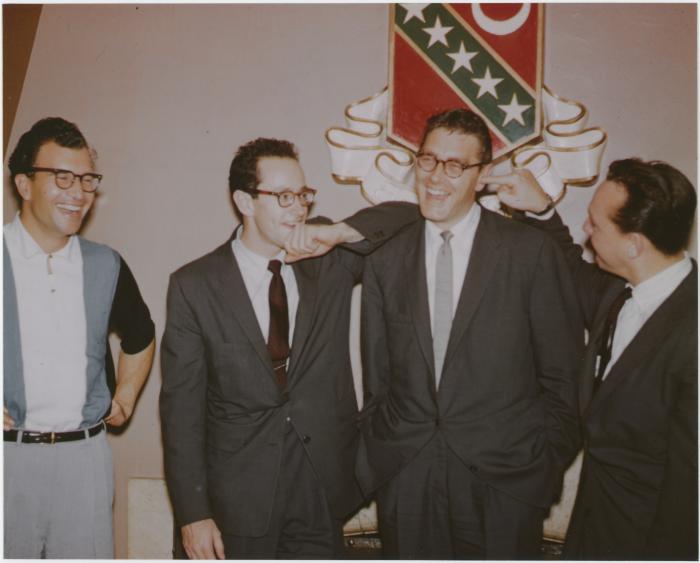 Dave Brubeck with his hands on his hips laughing; Paul Desmond resting his arm on Joe Dodge's shoulder and Bob Bates with his finger stuck in Joe's ear (Kansas University, Lawrence, Kansas)