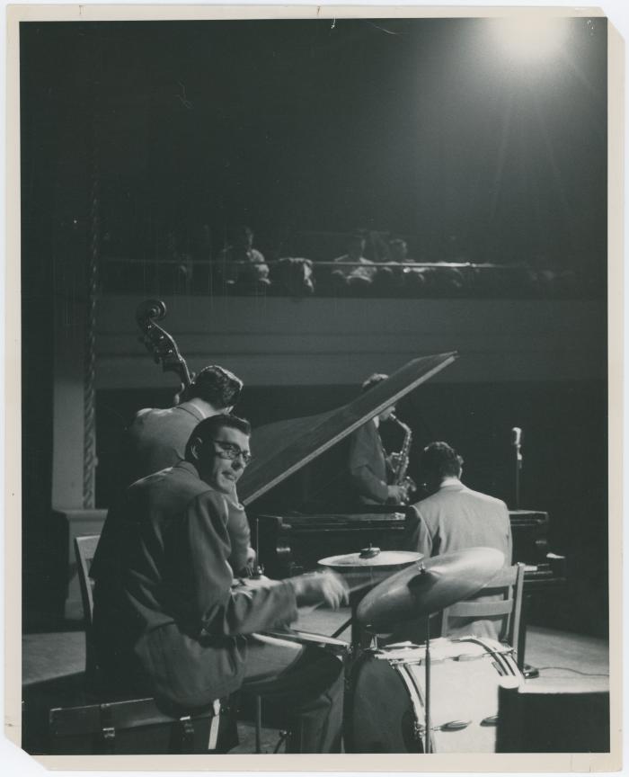 Dave Brubeck at piano, Paul Desmond (obscured by piano lid), Bob Bates (back to camera), Joe Dodge in performance