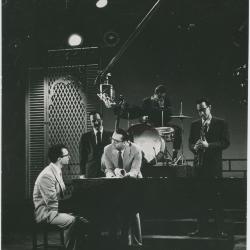Dave Brubeck at piano, Steve Allen leaning on piano, with Bob Bates, Paul Desmond, and Joe Dodge on Steve Allen TV Show (New York City, New York)