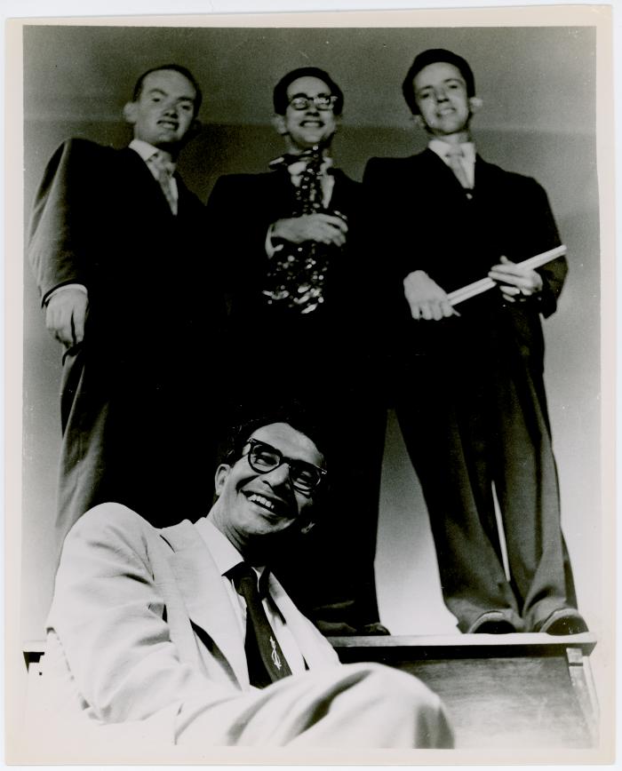 Dave Brubeck seated, Paul Desmond, Lloyd Davis, Ron Crotty all standing on upright piano