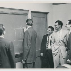 Dave Brubeck, Paul Desmond, Bob Bates, unidentified man, and Joe Dodge (writing on blackboard) (Denver, Colorado?)
