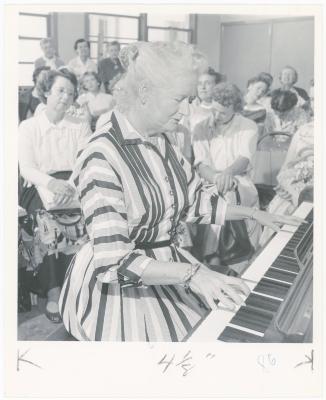 Mrs. Helen Devereaux of Albany playing piano while class watches during a "Dave teaches teachers" session for Alameda County school teachers (California)