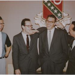 Dave Brubeck with his hands on his hips laughing; Paul Desmond resting his arm on Joe Dodge's shoulder and Bob Bates with his finger stuck in Joe's ear (Kansas University, Lawrence, Kansas)