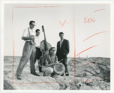 Dave Brubeck, Paul Desmond, Bob Bates, Joe Dodge with instruments on beach at Newport Jazz Festival (Newport, Rhode Island)