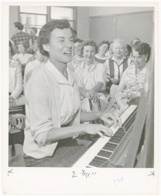 Mrs. Geraldine Hutt of Albany playing piano while class watches during a "Dave teaches teachers" session for Alameda County school teachers (California)