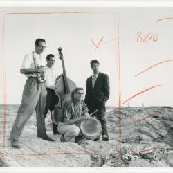 Dave Brubeck, Paul Desmond, Bob Bates, Joe Dodge with instruments on beach at Newport Jazz Festival (Newport, Rhode Island)