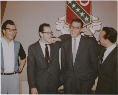Dave Brubeck with his hands on his hips laughing; Paul Desmond resting his arm on Joe Dodge's shoulder and Bob Bates with his finger stuck in Joe's ear (Kansas University, Lawrence, Kansas)