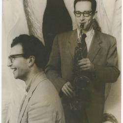 Dave Brubeck, Paul Desmond with saxophone against stylized flames background (New York City, New York)