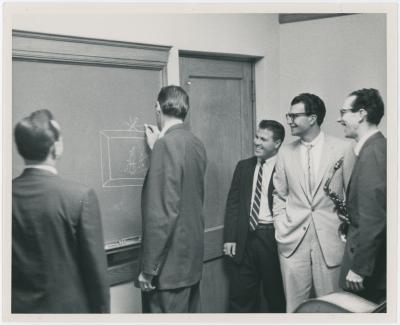 Dave Brubeck, Paul Desmond, Bob Bates, unidentified man, and Joe Dodge (writing on blackboard) (Denver, Colorado?)