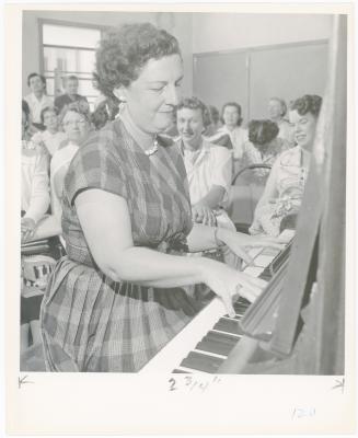 Mrs. Frances Kamps of El Cerrito playing piano while class watches during a "Dave teaches teachers" session for Alameda County school teachers (California)