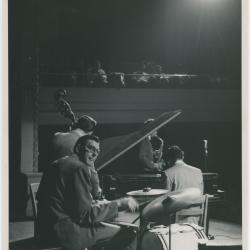 Dave Brubeck at piano, Paul Desmond (obscured by piano lid), Bob Bates (back to camera), Joe Dodge in performance