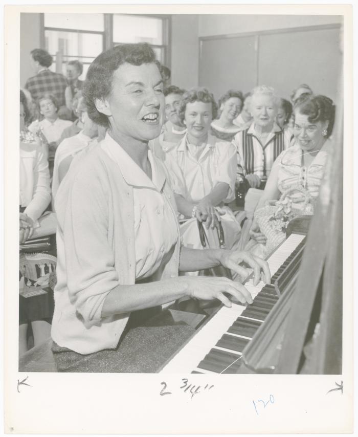 Mrs. Geraldine Hutt of Albany playing piano while class watches during a "Dave teaches teachers" session for Alameda County school teachers (California)