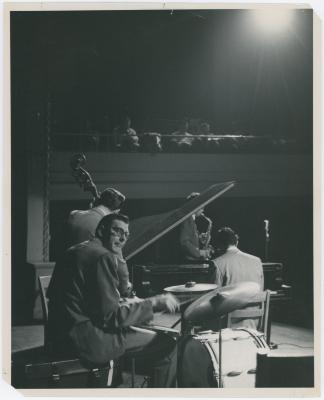 Dave Brubeck at piano, Paul Desmond (obscured by piano lid), Bob Bates (back to camera), Joe Dodge in performance