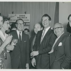 Two unidentified women, J. Baverstock, Dave Brubeck, and two unidentified men (L-R) at a reception honoring him, Buck Clayton and Jimmy Rushing (London, United Kingdom)