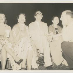 Dave Brubeck and Iola Brubeck (seated), George Avakian (kneeling), 2 unidentified women (seated) listening to concert at Newport Jazz Festival (Newport, Rhode Island)