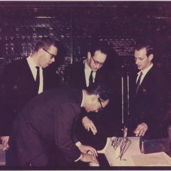 Dave Brubeck standing and playing piano, Paul Desmond, Norman Bates, Joe Morello listening