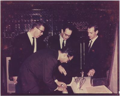 Dave Brubeck standing and playing piano, Paul Desmond, Norman Bates, Joe Morello listening
