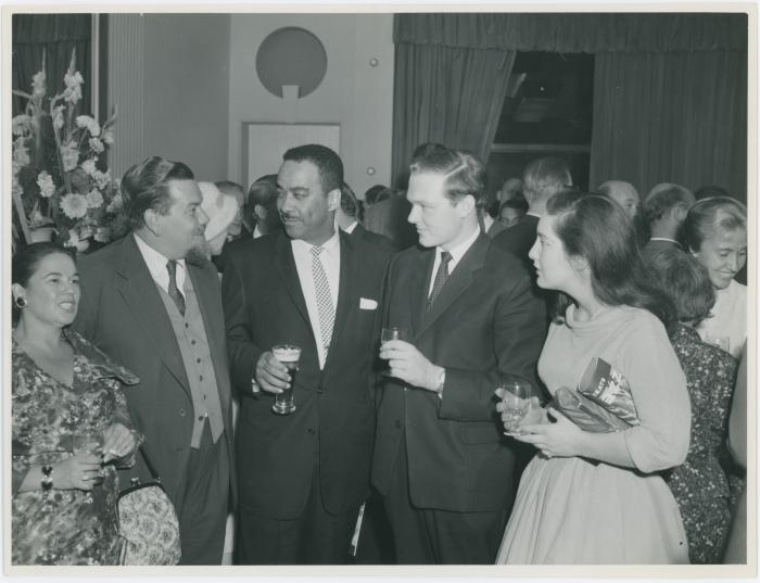 Buck Clayton, two unidentified women and men attending a reception honoring him, Dave Brubeck and Jimmy Rushing (London, United Kingdom)