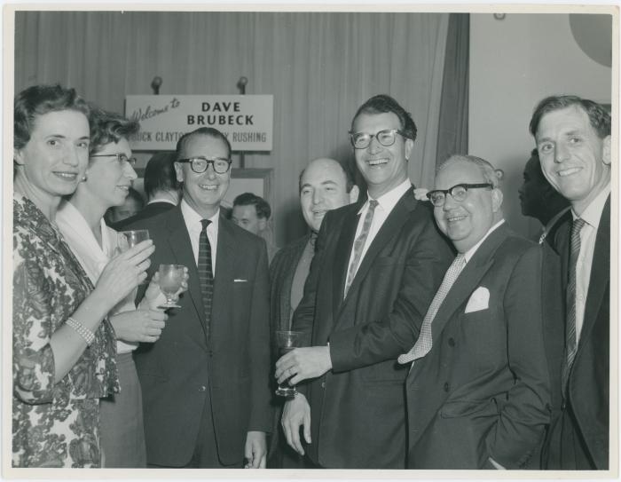 Two unidentified women, J. Baverstock, Dave Brubeck, and two unidentified men (L-R) at a reception honoring him, Buck Clayton and Jimmy Rushing (London, United Kingdom)