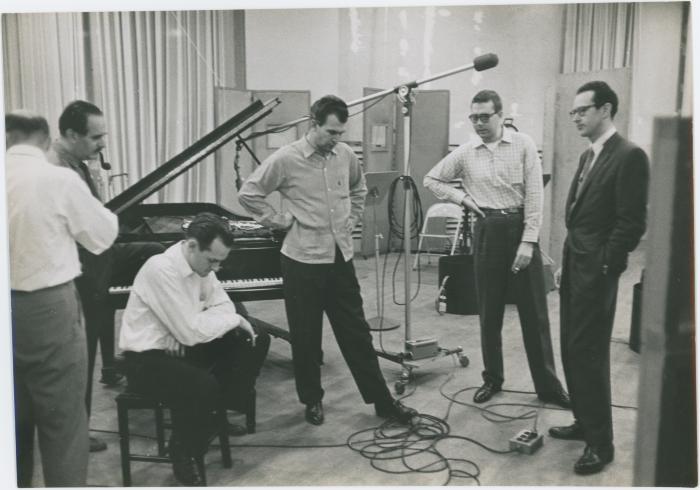 George Avakian and Fred Plant (smoking pipe, Columbia producer and recording engineer), with Norman Bates (seated), Dave Brubeck, Joe Morello, and Paul Desmond listening to playback #2 (New York City, New York [?])