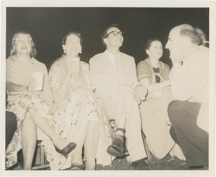 Dave Brubeck and Iola Brubeck (seated), George Avakian (kneeling), 2 unidentified women (seated) listening to concert at Newport Jazz Festival (Newport, Rhode Island)