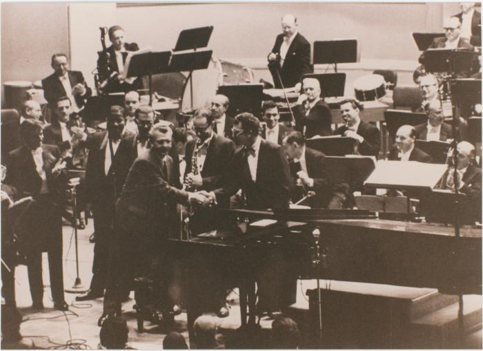 Howard Brubeck shaking hands with Dave Brubeck, (L-R) Eugene Wright, Joe Morello, Paul Desmond, Leonard Bernstein (applauding), members New York Philharmonic Orchestra, following a performance of Howard Brubeck's "Dialogues…" (New York City, New York)