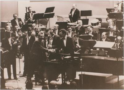 Howard Brubeck shaking hands with Dave Brubeck, (L-R) Eugene Wright, Joe Morello, Paul Desmond, Leonard Bernstein (applauding), members New York Philharmonic Orchestra, following a performance of Howard Brubeck's "Dialogues…" (New York City, New York)