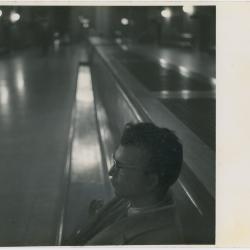 Dave Brubeck in profile, seated on train station bench