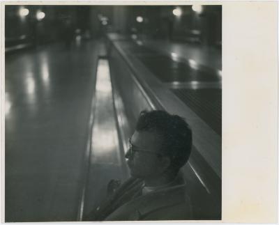 Dave Brubeck in profile, seated on train station bench