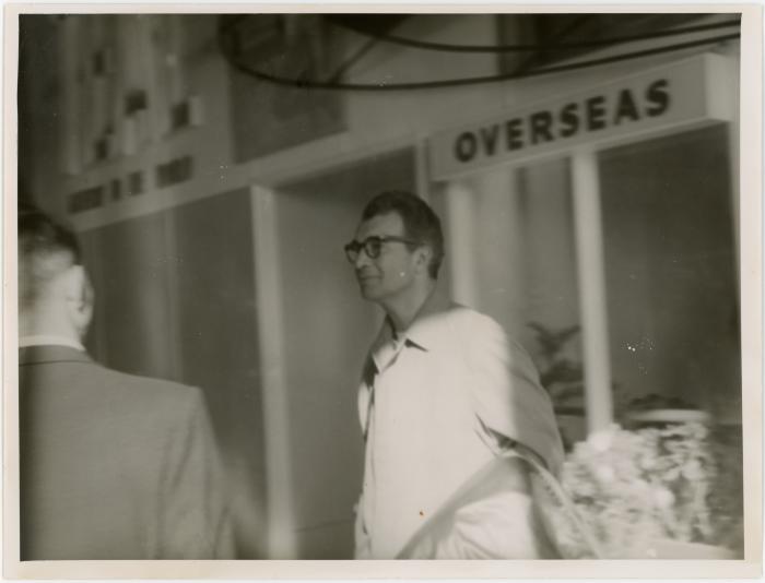 Dave Brubeck at airport with "overseas" sign and unidentified man (Wellington, New Zealand)