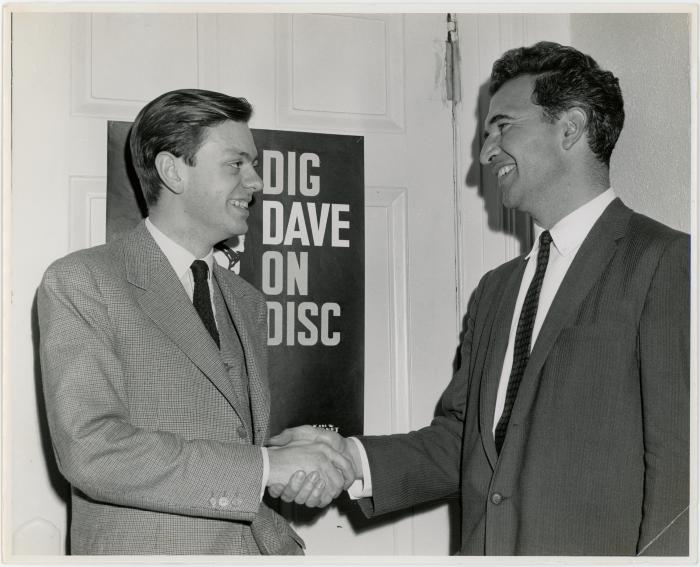 Dave Brubeck shaking hands with classical pianist, Phillippe Entremont in front of the "Dig Dave on Disc" sign (Adelaide, Australia)