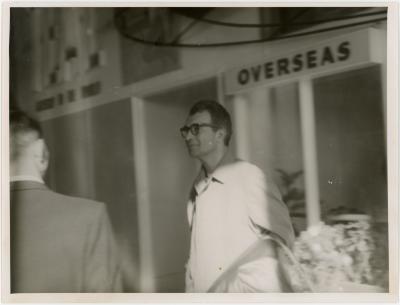Dave Brubeck at airport with "overseas" sign and unidentified man (Wellington, New Zealand)