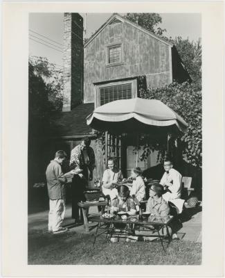 Dave Brubeck, Iola Brubeck, and their children eating under an umbrella at Irving Townsend house (Wilton, Connecticut)