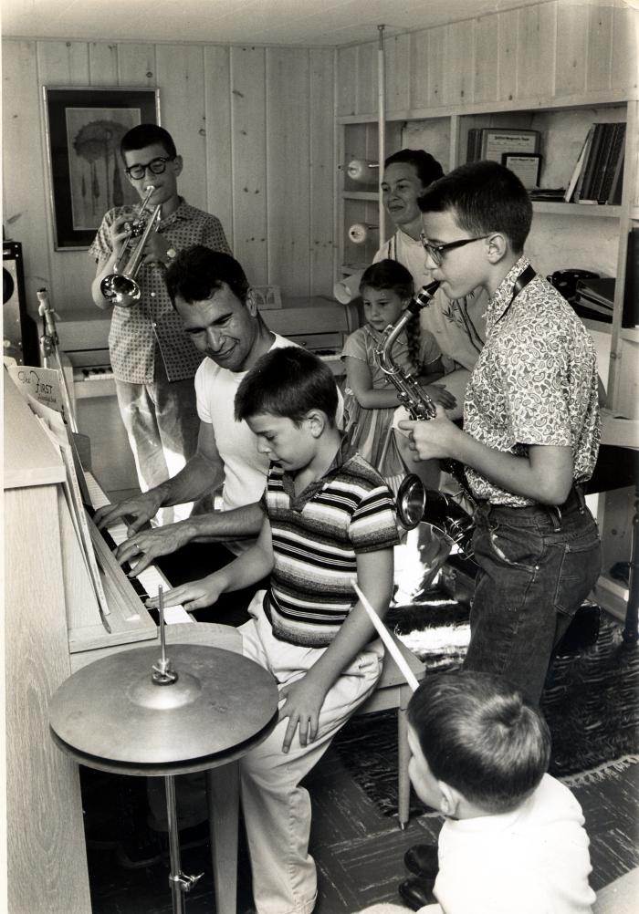 Dave Brubeck giving music lesson to Darius Brubeck, Michael Brubeck, Chris Brubeck, Dan Brubeck, with Iola Brubeck and Catherine Brubeck watching (Wilton, Connecticut)