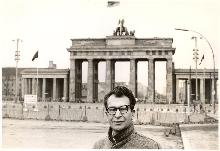 Dave Brubeck wearing an overcoat and glasses at the Brandenburg Gate (Berlin Wall, Berlin, West Germany)